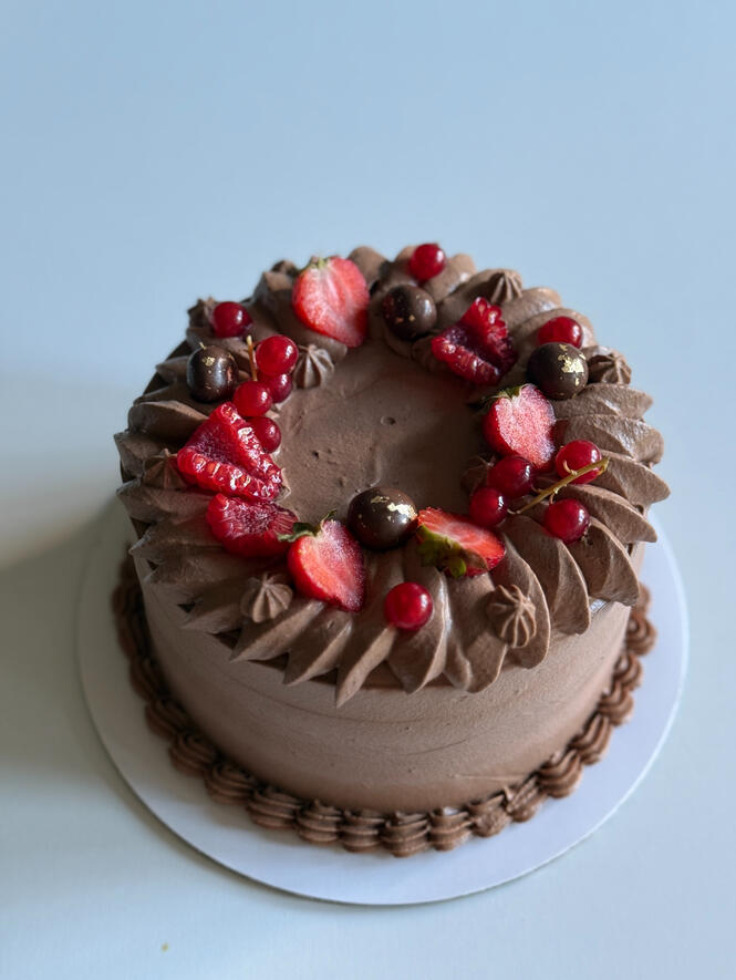 dark chocolate birthday cake with strawberry and small flowers