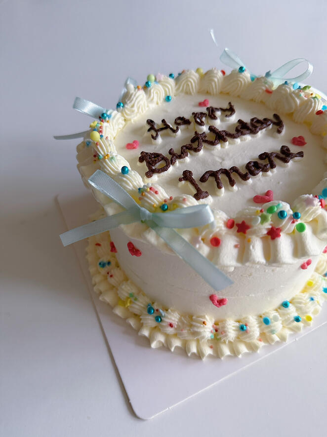 13 cm white birthday cake with bows and sprinkles